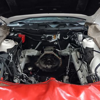 Midnight Auto - Empty engine bay of a 2014 Ford Mustang after removing the engine for a rebuild. - Auto Repair Near Me