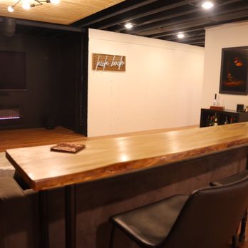 Square East building - Basement finishing with slat ceiling, black paint & custom live edge olive wood console table, - General Contractors Near Me
