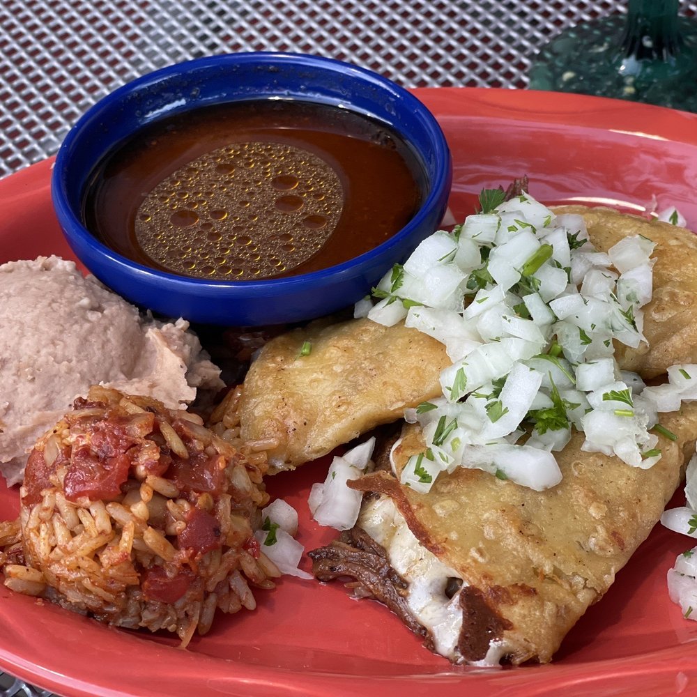 Red Mesa Grill - Quesabirria Tacos: cooked beef folded into a tortilla with melted cheese and served with a side of broth for dipping. - Latin American Near Me - Boyne City, Michigan Red Mesa Grill - Quesabirria Tacos: cooked beef folded into a tortilla with melted cheese and served with a side of broth for dipping. - Latin American Near Me - Boyne City, Michigan