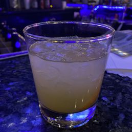 a drink in a glass on a table a drink in a glass on a table