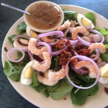 Capt'n Con's Fish House - Spinach salad, with warm bacon dressing topped with fresh shrimp - Seafood Near Me - Bokeelia, Florida Capt'n Con's Fish House - Spinach salad, with warm bacon dressing topped with fresh shrimp - Seafood Near Me - Bokeelia, Florida