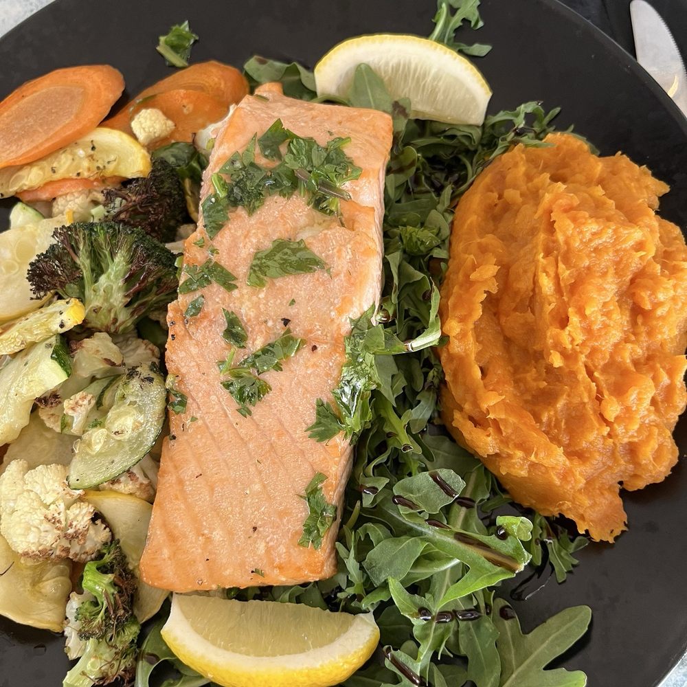 The baked salmon entree with sweet potatoes and roasted vegetables. The baked salmon entree with sweet potatoes and roasted vegetables.