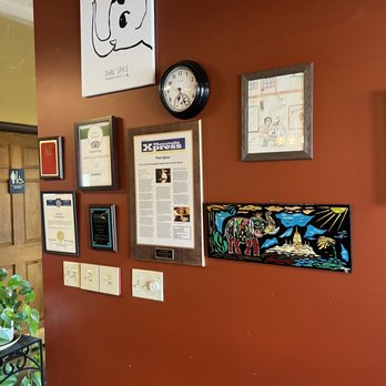 Thai Spice - a wall with a clock and posters on it - Thai Near Me - Hendersonville, North Carolina Thai Spice - a wall with a clock and posters on it - Thai Near Me - Hendersonville, North Carolina