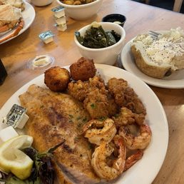 Platter trio (grouper, shrimp, oysters) with a baked potato and greens Platter trio (grouper, shrimp, oysters) with a baked potato and greens