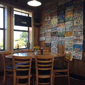 Stubby's BBQ - Table and wall of license plates in the back left corner of the place. - Barbeque Near Me - Hot Springs, Arkansas