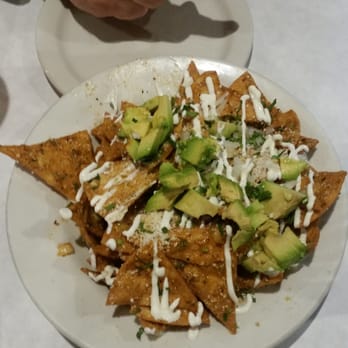 Frontier Public House - TOTOPOS CON CHILE FRESH TORTILLA CHIPS COATED IN CHILE ARBOL SALSA, COTIJA CHEESE, CILANTO & CREMA - New American Near Me - Vancouver, Washington