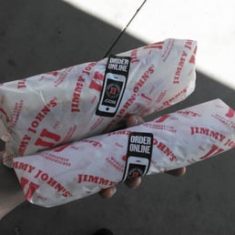 two sandwiches wrapped in paper two sandwiches wrapped in paper