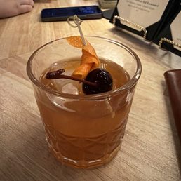 The most special Manhattan with a charred orange slice and a unique dark cherry- The big square ice cube is a major appeal The most special Manhattan with a charred orange slice and a unique dark cherry- The big square ice cube is a major appeal
