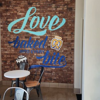 Cinnabon - a table and chairs in front of a brick wall - Bakeries Near Me - Elk Grove, California