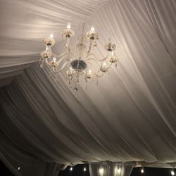 20x30 tent, drapped in white, with chandelier.