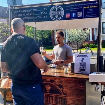 Nickel City Nitro - a man serving a drink to another man - Coffee & Tea Near Me Nickel City Nitro - a man serving a drink to another man - Coffee & Tea Near Me