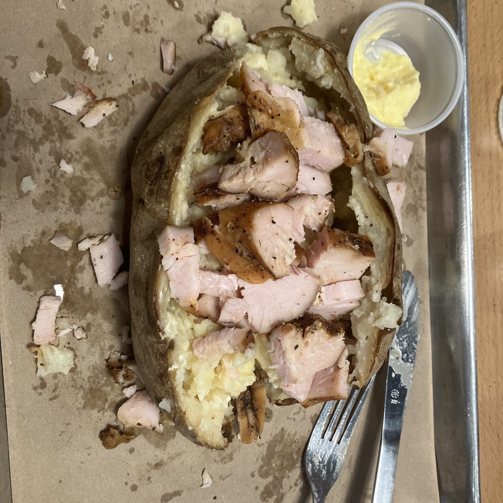 Baked potato with turkey, butter and sour cream. Baked potato with turkey, butter and sour cream.