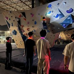 Rock Haven Climbing - Headlamp climbing event with people watching a climber on the wall, everyone is wearing glowing necklaces