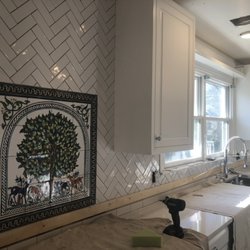 Masco Tile - Custom hand painted backsplash mural from Jerusalem with herringbone field tile.