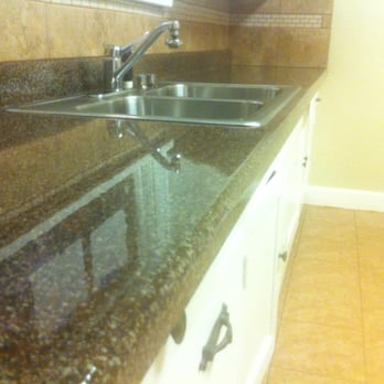 Ideal Resurfacing - a kitchen with granite countertops - General Contractors Near Me