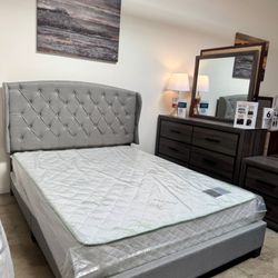 Affordable Home Furniture - Soft gray upholstered bed with matching bedroom furniture.