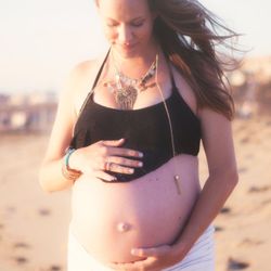 Sam Hoppes - Woman holding her pregnant belly