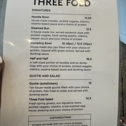 Front side of menu: signature dishes, Guotie and Salad options Front side of menu: signature dishes, Guotie and Salad options