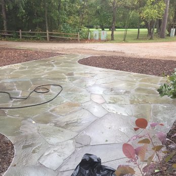 Lawn Boys - a black trash bag sitting on a stone patio - Landscaping Near Me - Bangor, Michigan