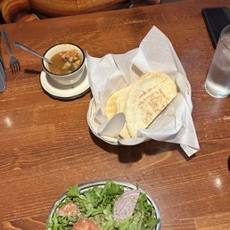 Salad, pita, and seafood soup