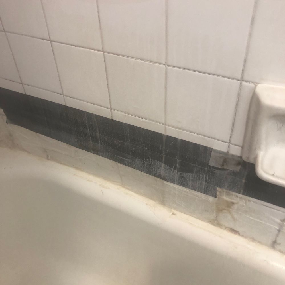 Bathroom titles held with duck tape.