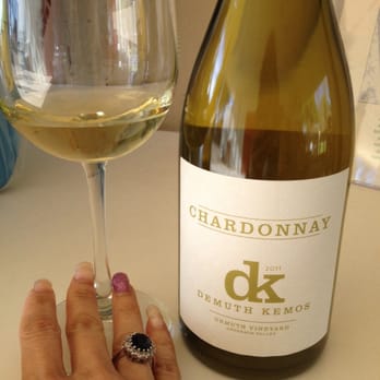 The Demuthery - a hand holding a wine glass and a bottle of chardonnay - Wineries Near Me - Windsor, California The Demuthery - a hand holding a wine glass and a bottle of chardonnay - Wineries Near Me - Windsor, California