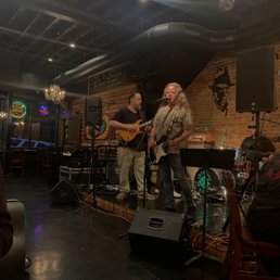 two men playing guitar and singing