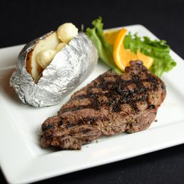 Grille 22 - a steak and a baked potato on a plate - steak, food - New American Near Me - Guin, Alabama