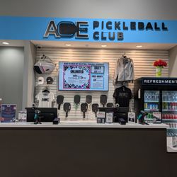 Ace Pickleball Club - Des Plaines - Front desk w/ gear, paddles (demos & for sale) and drinks