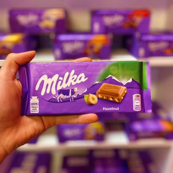 Eurovap - a hand holding a milka chocolate bar - Vape Shops Near Me - Laval, Quebec
