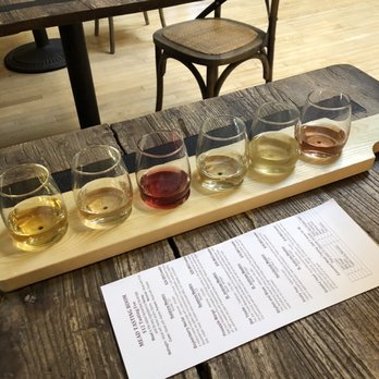 Savannah Bee - a flight of wine glasses on a wooden table - Cosmetics & Beauty Supply Near Me - Boulder, Colorado