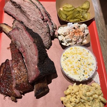 Terry Black's Barbecue - Our plate - brisket, beef rib, pork ribs, pickles, potato salad, creamed corn and mac&cheese - Barbeque Near Me - Houston, Texas