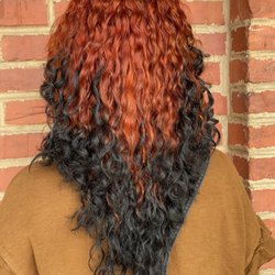 The Junction Salon and Bar - Fiery dimension with a moody twist. Rich copper tones melt into deep black curls for a statement look that's parts bold and beautiful!