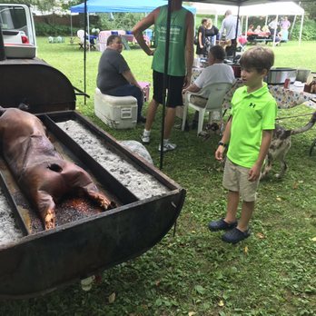 Divine Swine - a young boy standing next to a bbq - Caterers Near Me - Broadalbin, New York
