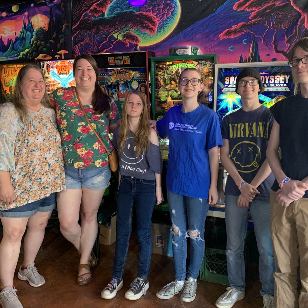 Cattletown Eclectic Arcade - Family photo at the arcade with pinball machines in the background. - Candy Stores Near Me - Springerville, Arizona