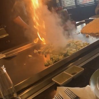 Little Tokyo - a person cooking food on a grill - Sushi Bars Near Me - Pigeon Forge, Tennessee