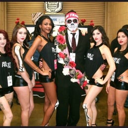a man in a tuxedo posing with a group of girls a man in a tuxedo posing with a group of girls