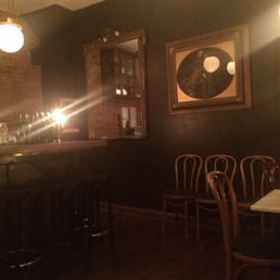 a dimly lit bar with wooden chairs