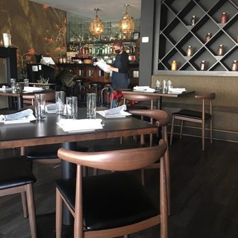 Coriander Modern Indian - a dining area with wooden tables and chairs - Indian Near Me - Larchmont, New York Coriander Modern Indian - a dining area with wooden tables and chairs - Indian Near Me - Larchmont, New York