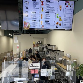 Hi Boba - Inside Hi Boba in Rio Rancho, NM, staff are preparing drinks behind the counter, with a large digital menu screen above displaying various tea and beverage options. - Coffee & Tea Near Me - Rio Rancho, New Mexico