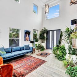 Casa Hermès, Wilton Manors FL - Gay Guest House - A vibrant living room in an LGBT-friendly hotel in Wilton Manors, FL. The room features colorful decor with rainbow accents, ...