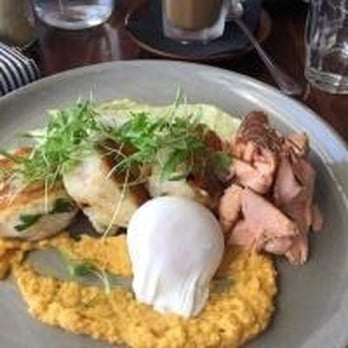 Seven VII South - Potato and parmesan cakes with pumpkin hummus, avocado aioli, bacon and poached egg - Juice Bars & Smoothies Near Me - Yeronga, QLD Seven VII South - Potato and parmesan cakes with pumpkin hummus, avocado aioli, bacon and poached egg - Juice Bars & Smoothies Near Me - Yeronga, QLD