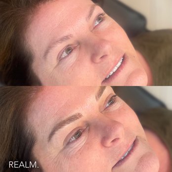 REALM - Before and after. - Two close-up images of a woman's face are displayed, focusing on her eyebrows. The top image shows her natural eyebrows, while the bottom image shows her eyebrows after microblading, appearing more defined and shaped. The woman has light skin, brown hair, and is lying down with her eyes open. The images emphasize the cosmetic enhancement of eyebrow microblading, with the second photo including a watermark reading 'REALM.' - Cosmetics & Beauty Supply Near Me - Redding, California