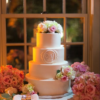 Royal Icings - Buttercream in ivory with piped buttercream bead border and hand-made fondant monogram and fresh florals. photo sandra costello - Wedding Planning Near Me Royal Icings - Buttercream in ivory with piped buttercream bead border and hand-made fondant monogram and fresh florals. photo sandra costello - Wedding Planning Near Me