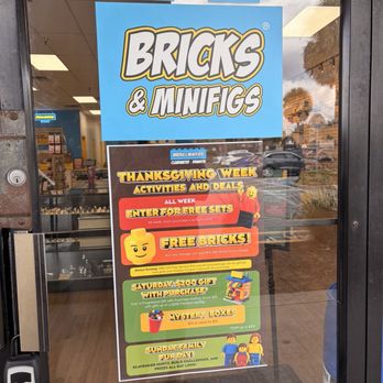 Bricks And Minifigs - Thanksgiving events - A colorful poster displayed on the glass door of Bricks & Minifigs, advertising Thanksgiving Week activities, deals, and giveaways, including free sets and mystery boxes. - Toy Stores Near Me - Brandon, Florida