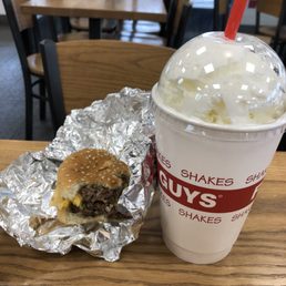 a hamburger and a drink on a table