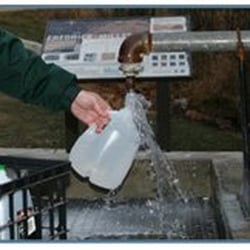Fredrick-Miller Spring - A photo of the spring, and somebody filling up a water jug.