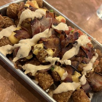 The Quarry Taphouse - Totchos YUM Tots / Homemade cheese sauce / Bacon / Diced tomato / Red onion / Chipotle crema - Sports Bars Near Me - Hastings, Minnesota