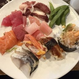 sashimi, few pieces of sushi and edamame on the side. sashimi, few pieces of sushi and edamame on the side.