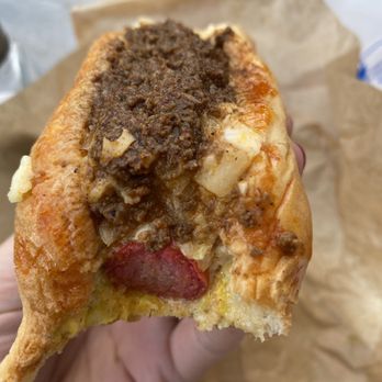 The Dog House - a hand holding a piece of food - Hot Dogs Near Me - Durham, North Carolina The Dog House - a hand holding a piece of food - Hot Dogs Near Me - Durham, North Carolina